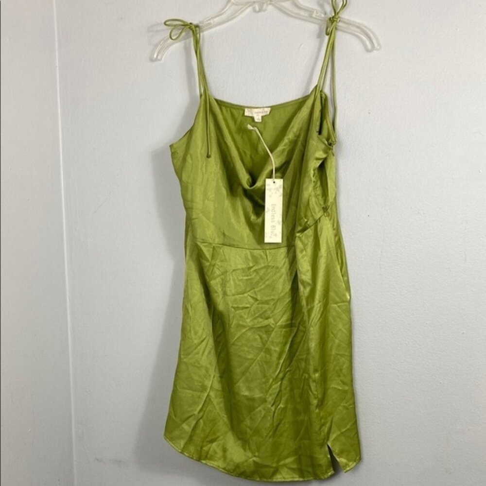 green satin mini dress with a cowl neck and tie-up spaghetti straps